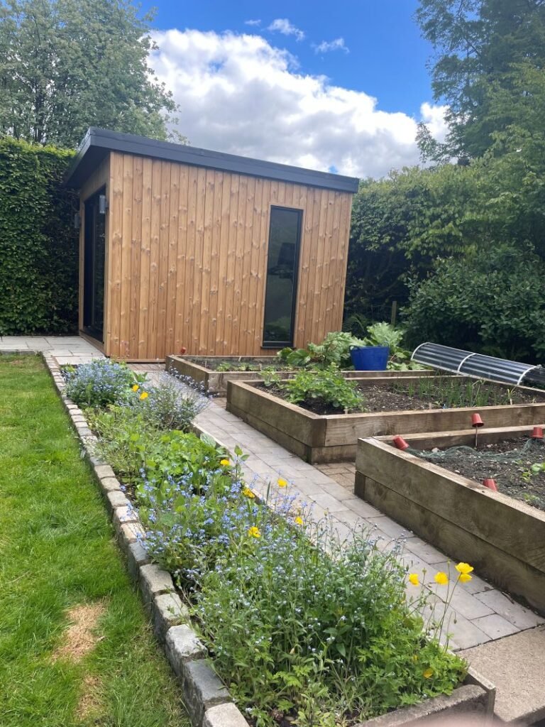 garden gym in macclesfield cheshire by lux garden rooms finished in front of flowers