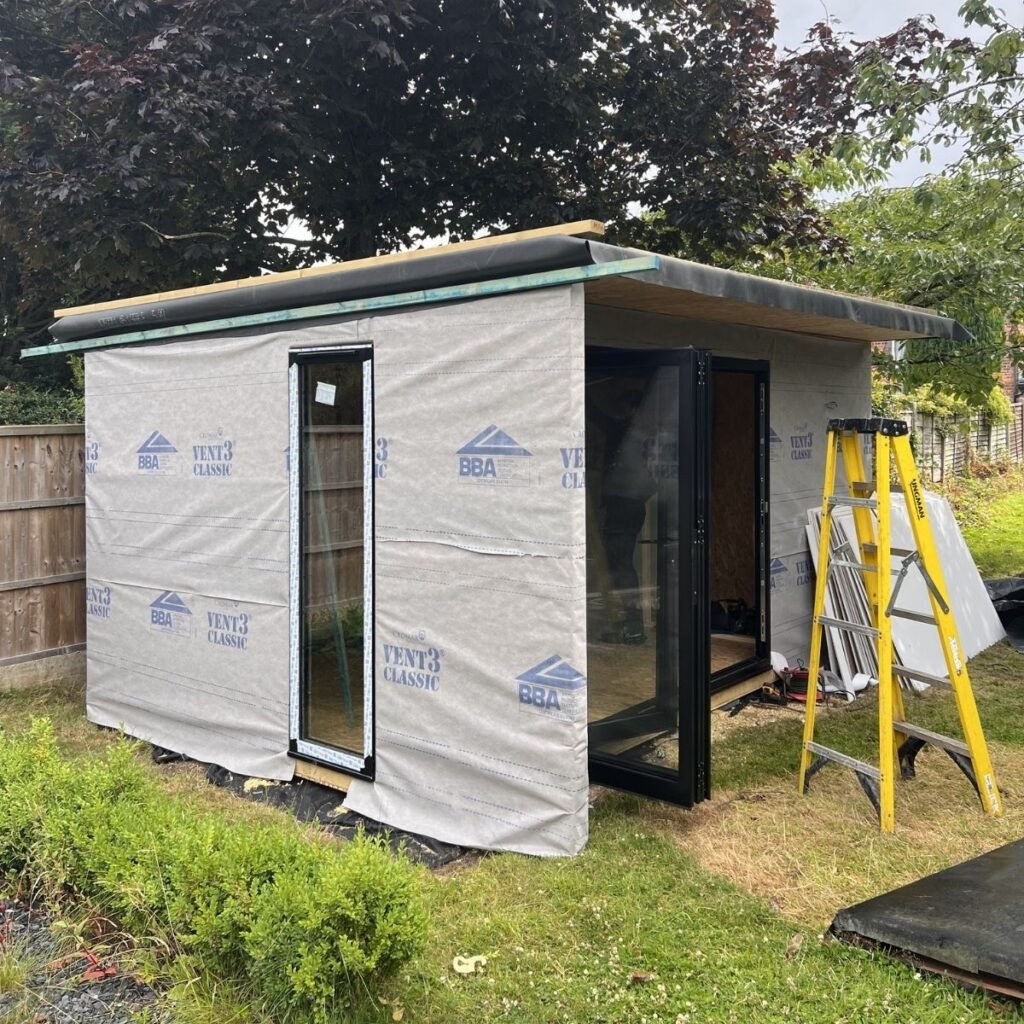 membrane being installed on top of sip panels for the garden office